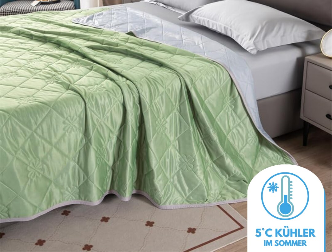 Kühldecke in Grün auf einem gemachten Bett in einem modernen Schlafzimmer